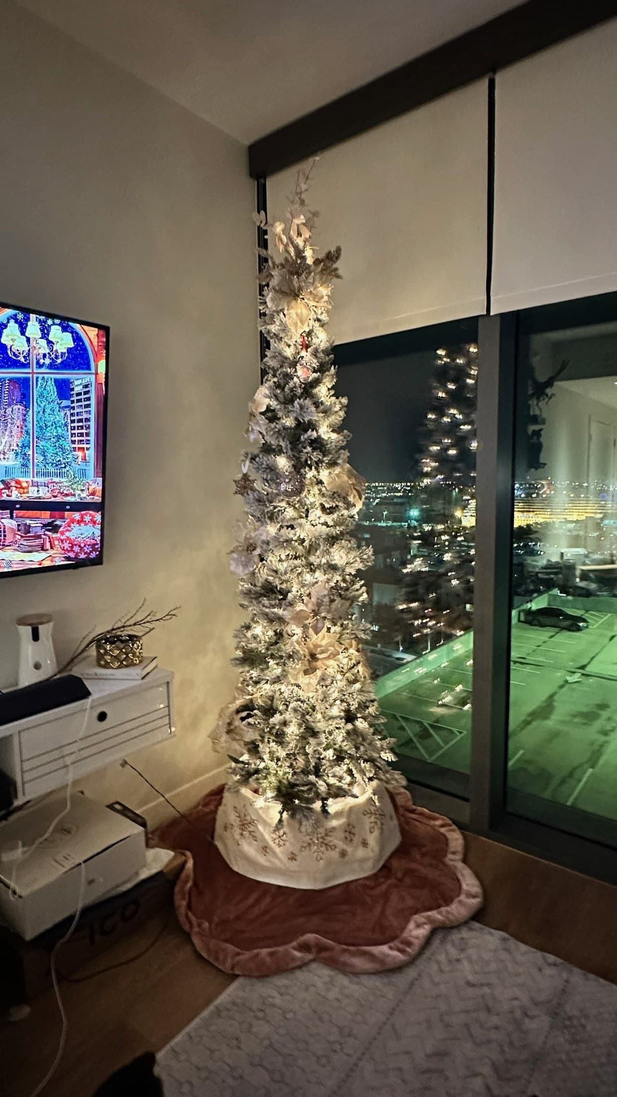 Warm pencil Christmas tree glowing at night beside a window with ribbon and ornaments.